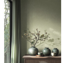 Dekorativa vaser och skålar på ett träskåp bredvid ett fönster