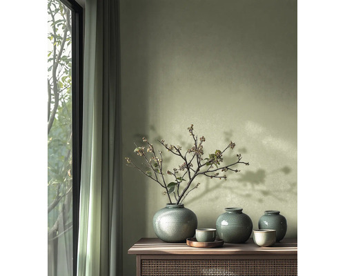 Dekorativa vaser och skålar på ett träskåp bredvid ett fönster