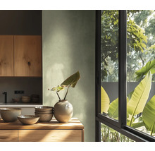 Ljust kök med träelement, porslin och fönster med utsikt över grönska