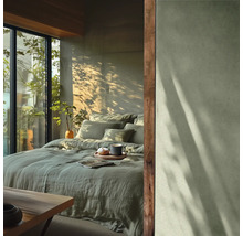 Sovrum med sängkläder, kuddar, dryck och naturligt ljus