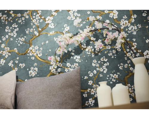 Närbild av en vägg med blommig tapet, kuddar och dekorativa vaser.