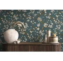 Dekorativ interiör med en byrå, vaser och en blommig tapet.