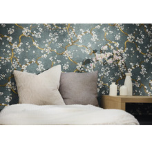 Dekorativt sovrum med en blommig tapet, kuddar och vaser