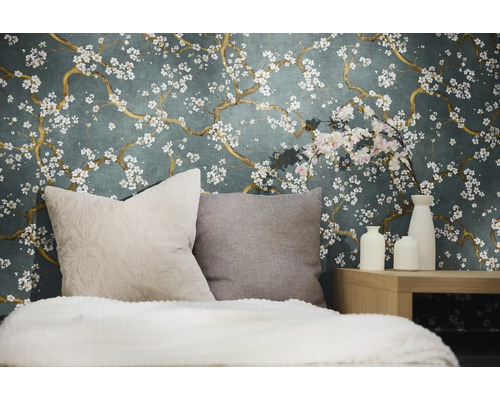 Dekorativt sovrum med en blommig tapet, kuddar och vaser