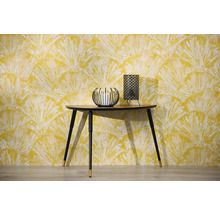 Scen med konsolbord, ljusstake och bordslampa framför en mönstrad tapet