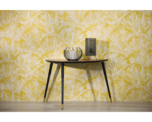 Scen med konsolbord, ljusstake och bordslampa framför en mönstrad tapet