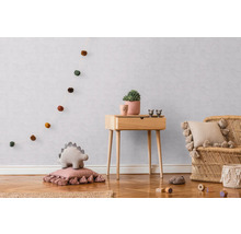 Barnrum med träbyrå, rottingfåtölj och dekorativa tillbehör