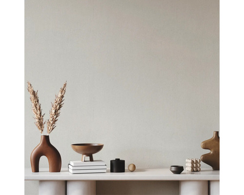 Dekorativ arrangemang med vaser, skålar och böcker på en hylla.