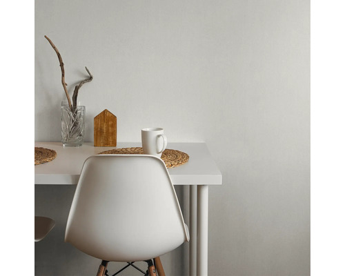 Vitt bord med dekorationer, inklusive ett glas, ett trähus och en mugg