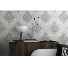 Dekorativt vardagsrum med mönstrad tapet och träskänk