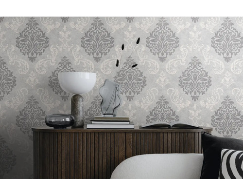 Dekorativt vardagsrum med mönstrad tapet och träskänk