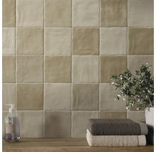 Väggkakel i badrum med tvålpump, handdukar och växt