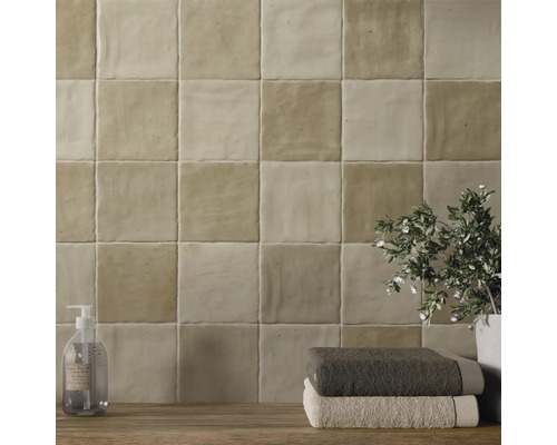 Väggkakel i badrum med tvålpump, handdukar och växt