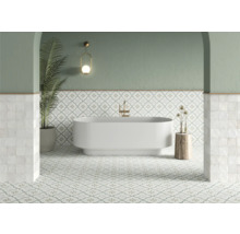 Badrum med badkar, klinkergolv och vägglampa