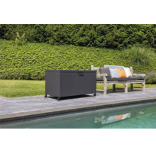 Scen med en förvaringslåda på hjul bredvid en trädgårdsbänk på en terrass vid en pool