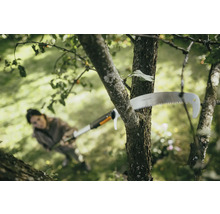 Kvinna sågar gren med en grensax