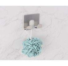 Duschsvamp hänger på en väggkrok i rostfritt stål