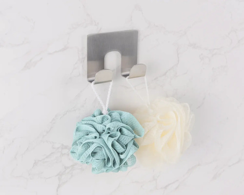 Toppvy av handdukshängare i rostfritt stål med badsvampar på en marmorvägg