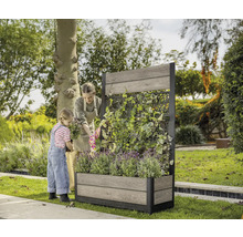 Kvinna och barn planterar en planteringslåda med spaljé i trädgården.