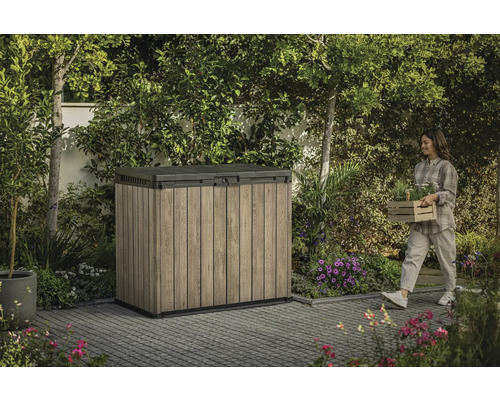 Trädgårdsskåp utomhus med kvinna som bär växter