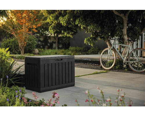 Trädgårdsscen med en förvaringslåda för utomhusbruk och en cykel