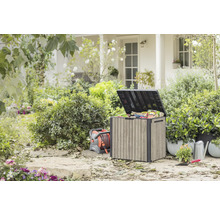 Utomhusträdgård med förvaringslåda, slangvinda, vattenkanna och växter