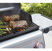 Gasolgrill med biffar och sparris på grillgallret