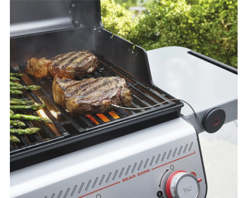 Gasolgrill med biffar och sparris på grillgallret