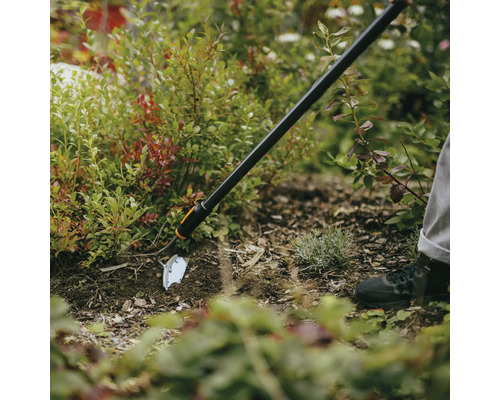 Trädgårdshacka som används i rabatten för jordbearbetning.