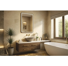 Ljust badrum med tvättställ, spegel med belysning, badkar och dekorativa element