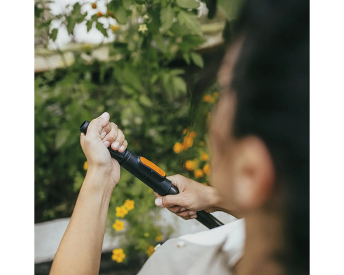 Person som håller trädgårdsslangmunstycke i handen