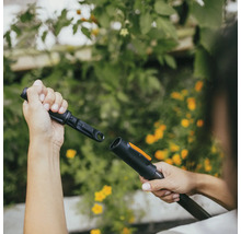 Person som ansluter trädgårdsredskap för trädgårdsbevattning