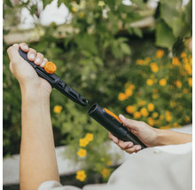 Två händer ansluter ett bevattningssystem från Fiskars.