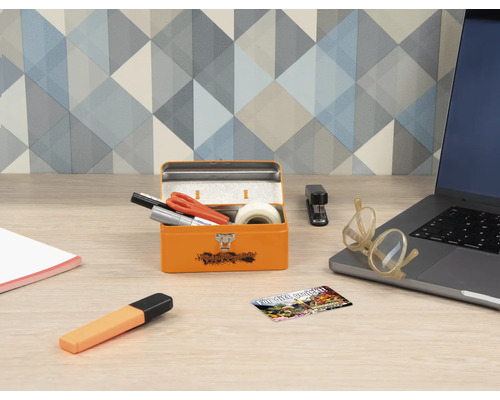 Skrivbordsscen med orange metallåda, kontorsmaterial och bärbar dator