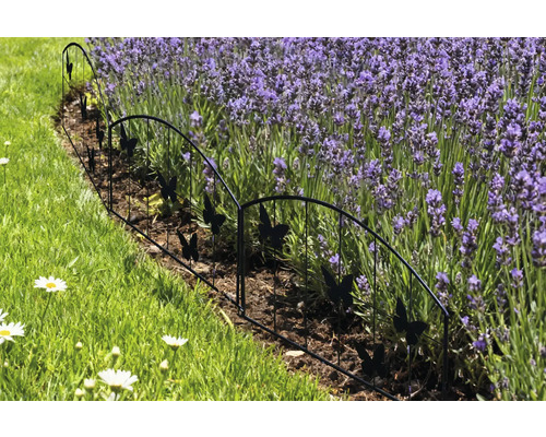 Trädgårdsstaket med fjärilsmotiv för att avgränsa en blomsterrabatt