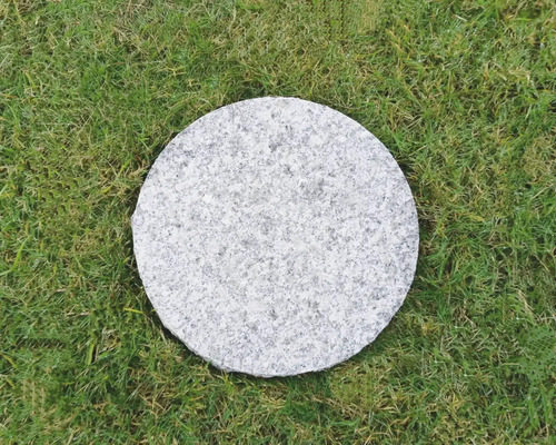 Rund trampsten av sten på gräsmatta