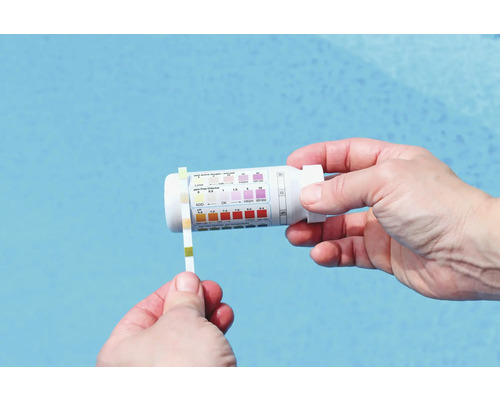 En person testar poolvattnet med en testremsa och ett testkit.