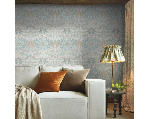 Vardagsrum med mönstrad tapet, soffa och golvlampa