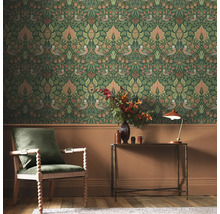 Scen av ett rum med dekorativ blomstertapet, en fåtölj och ett bord.