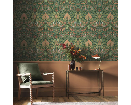 Scen av ett rum med dekorativ blomstertapet, en fåtölj och ett bord.