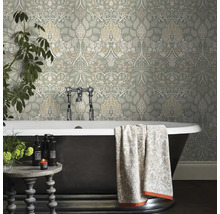 Badrum med blommönstrad tapet, badkar och sidobord.