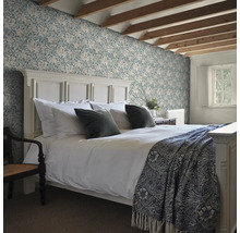 Sovrum med säng och blommig tapet