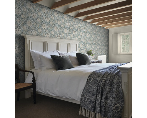 Sovrum med säng och blommig tapet