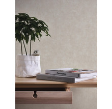 Närbild av ett bord med en växt i en pappersbehållare och två böcker