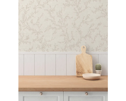 Miljöbild med en arbetsyta, en skärbräda i trä, en skål, en kaktus och en tapet med blommönster