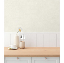 Scen med en ljusfärgad tapet, kombinerad med en bänkskiva i trä och köksredskap.