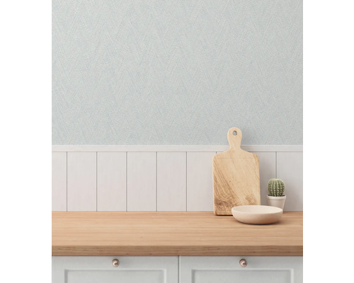 Scen med skärbräda, skål och kaktus på en köksbänk framför en strukturerad tapet