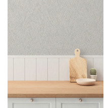 Dekorativ scen med en bänkskiva, en skärbräda i trä, en skål, en kaktus och en strukturerad tapet.