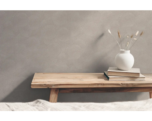 Vägg med cirkelmönster, träbord, vas och böcker