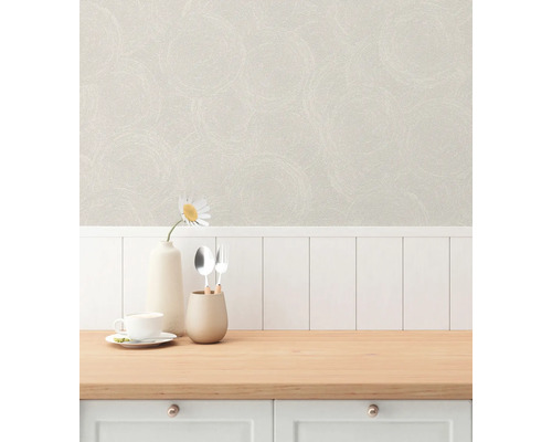 Scen med mönstrad tapet, porslin och dekoration på en köksbänk.